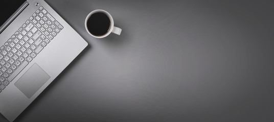 laptop and coffee cup on gray background with copy space. top view