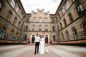 Beautiful portrait wedding couple near ancient restored architecture, old building, old house outside, vintage palace outdoor. Romantic love in vintage atmosphere street.