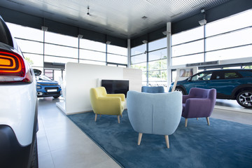 Comfortable armchairs for customers in the middle of a car showroom - obrazy, fototapety, plakaty