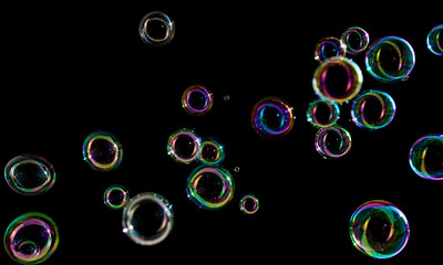 Soap bubbles on a dark background in motion.
