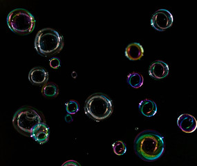 Soap bubbles on a dark background in motion.