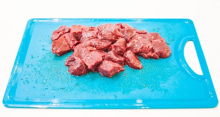 Whale row meat cut into the cubes on the cutting board. Isolated in white background.