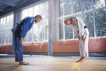 Two judo fighters or athletes greeting each other in a bow before practicing martial arts in a...