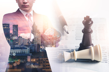 The double exposure image of the businessman thinking overlay with chess game and account book...