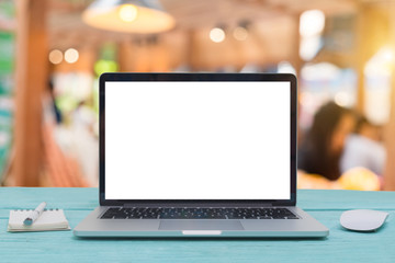 Computer notebook and mouse with a coffee shop behind the scenes Blur coffee shop