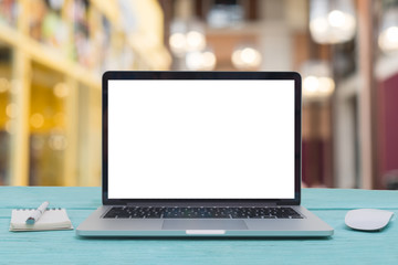 Computer notebook and mouse with a coffee shop behind the scenes Blur coffee shop
