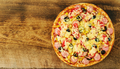 Homemade pizza with parmesan, oregano, olives and mozzarella, sausage and tomato sauce, top view, copy space