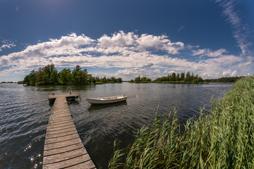 Boat and a jetty on a sunny summer day © DZiegler