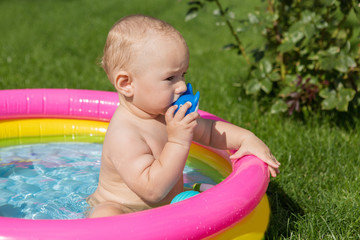 A small child is bathing in a pool, inflatable children's inflatable pool in summer	