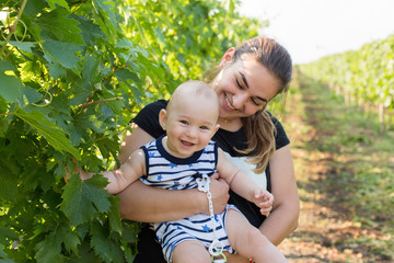 a young mother with a toddler in a vineyard in the summer