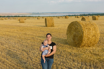 Naklejka na ściany i meble Mother with child in wheat