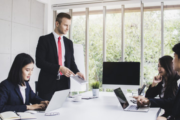 Market analysts person use laptop to planning and brain storming with marketing business people by looking at    growth finance graph  in office