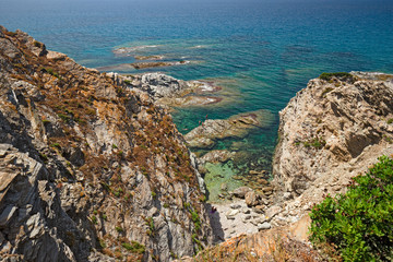 Panoramic view of the beach of "Porto Palmas" in Sardinia, Italy, with some sunbathers lying in the sun