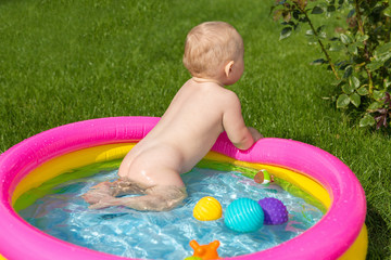 A small child is bathing in a pool, inflatable children's inflatable pool in summer