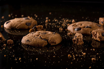 Sweet cookies with chocolate on black background