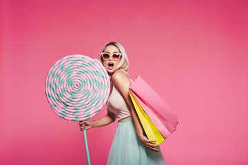 Cute model with sweets and shopping bags