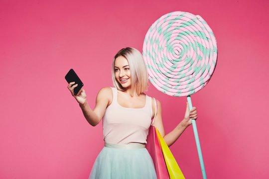 Beautiful  model with sweets at pink background