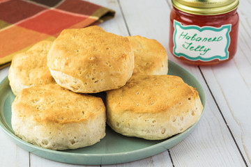 Fresh baked buttermilk biscuits and glass jars with habanero jelly.