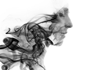 Double exposure portrait of a young woman and a smoky texture dissolving into her hair and face