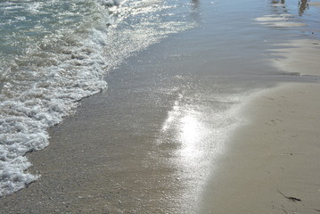 Yellow wet sand with thin, transparent waves of the black sea and sun shine and beauty from the water and the beach