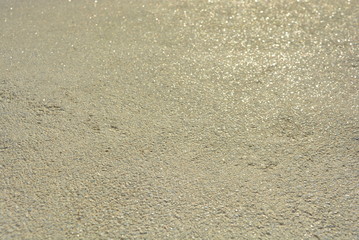 Yellow bright background, construction wall with very small glass stones matte white and gray with a reflection of the sun