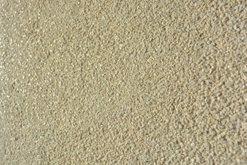 Yellow bright background, construction wall with very small glass stones matte white and gray with a reflection of the sun