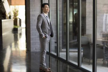 Confident businessman looking through window