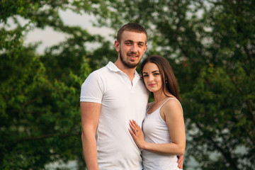 Fototapeta premium Dating in park. Love couple standing together on grass near the lake. Romance and love