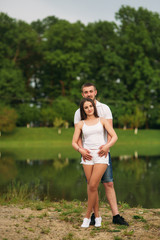 Couple in love hug each other near the lake