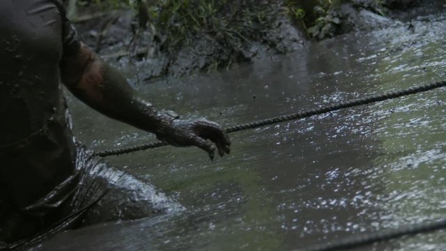people running a mud race high speed and slow motion