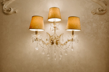 Photo of vintage crystal chandelier in the restaurant. Lamp on the wall.