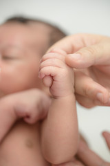 Newborn baby holding finger of mother / father. Happy Family and Baby protection concept. Mom and dad holding the hand of their child.