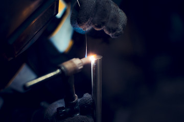 Argon-arc welding welder at the workplace welds the part - obrazy, fototapety, plakaty
