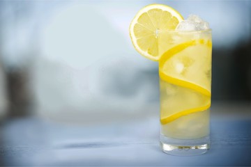 Lemonade with fresh lemon on desk