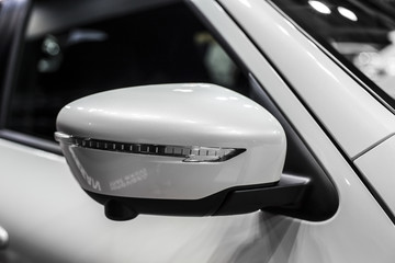 mirror of white compact SUV with turn signal, detail of car close-up
