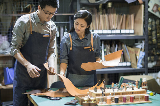 Young leather craftspeople working in studio 