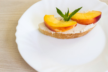Sandwich with cream cheese and nectarines. Fruit sandwich on a white plate.