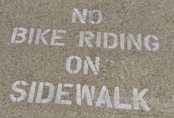 sidewalk warning of no bike riding