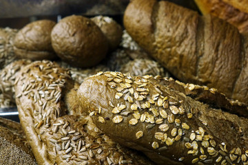 Bread with the addition of seeds and fruits on the table. The range of pastries.