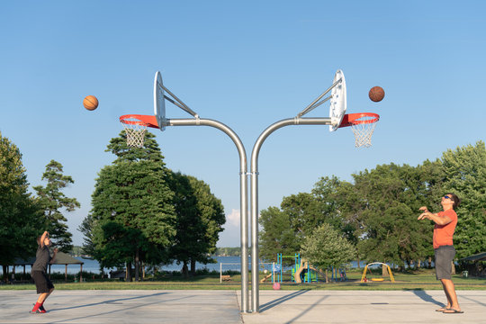 Boy and father throwing basketballs