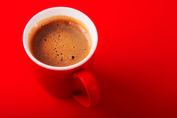 A cup of fragrant coffee on a red background for your design. Advertising coffee.