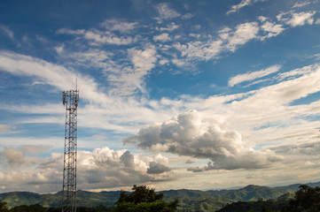 Telephone towers are located on high mountain, to transmit signals covering the area. with white clouds and blue sky background.
