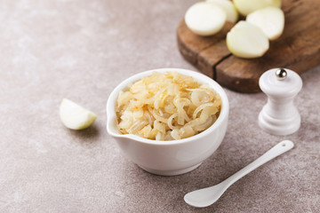 Homemade caramelized onions in frying pan. Vegetarian food..