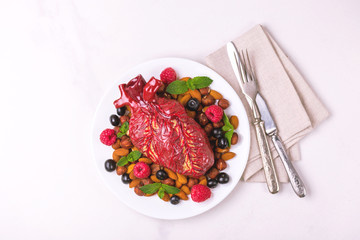 Healthy food and heart model. Nuts and berries. Medical abstract concept