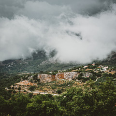 View on mountain with low hanging clouds and green trees. South Crete neat Rethymno, Greece