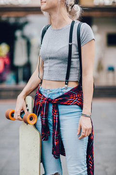 Portrait of young hipster woman with skateboard