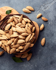 Unshelled almonds on gray concrete background. Top view.