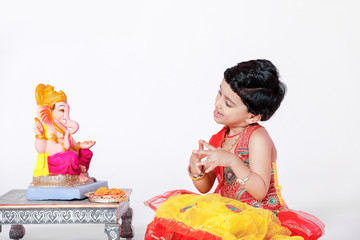 Little Indian girl child with lord ganesha and praying , Indian ganesh festival