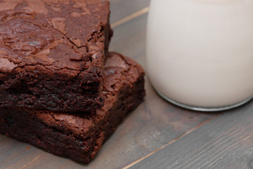 homemade cake chocolate brownies and milk on wooden table