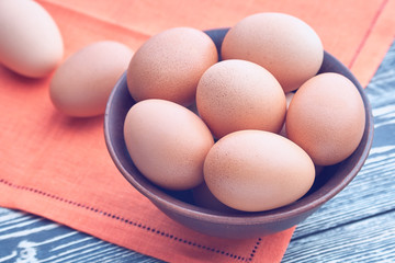 Eggs in a clay bowl on a wooden table